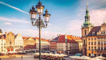 Sunny day in a European city square with historic buildings, str